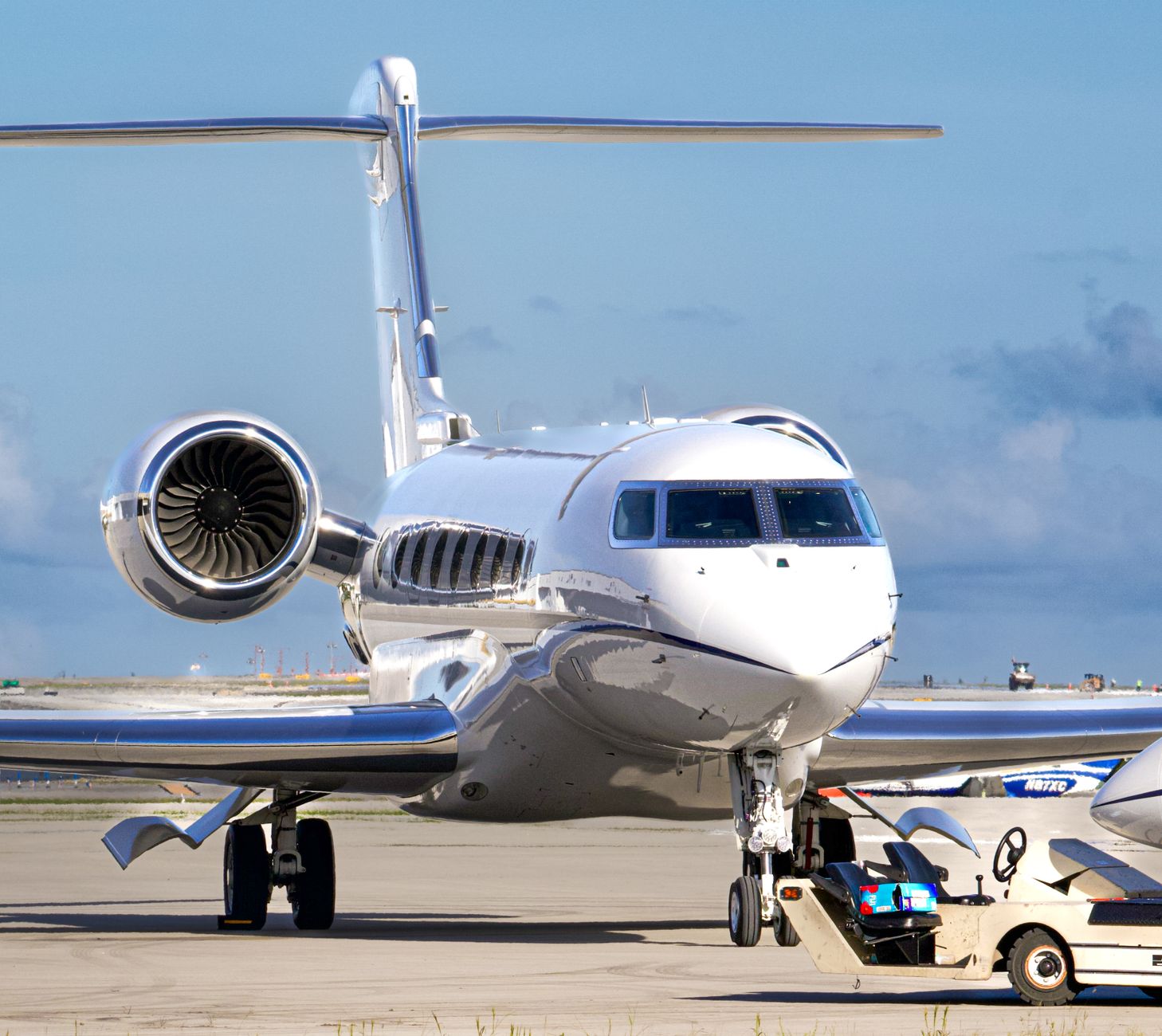 private jet on tarmac with ground support in daylight